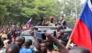 Burkina Faso's self-declared new leader Ibrahim Traore is welcomed by supporters holding Russian's flags as he arrives at the national television standing in an armoured vehicle in Ouagadougou, Burkina Faso, on October 2, 2022. (REUTERS/Vincent Bado) 