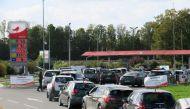 Car drivers queue to fill their fuel tanks at gasoline pumps at Auchan gas station in Petite-Foret, France, October 6, 2022. REUTERS/Pascal Rossignol/File Photo