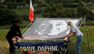 Activists unveil a banner of anti-corruption journalist Daphne Caruana Galizia that reads 
