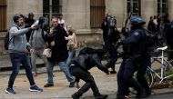 French riot police clash with a protestor at a demonstration in Paris as part of a nationwide day of strike and protests for higher wages and against requisitions at refineries in France, October 18, 2022. Reuters/Benoit Tessier