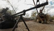 Ukrainian serviceman Yuriy smiles next to a machine gun captured from Russian troops at a position on a frontline in Mykolaiv region, Ukraine October 21, 2022. Reuters/Valentyn Ogirenko 