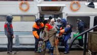 Civilians evacuated from the Russian-controlled city of Kherson walk from a ferry to board a bus heading to Crimea, in the town of Oleshky, Kherson region, Russian-controlled Ukraine, on October 23, 2022. REUTERS/Alexander Ermochenko