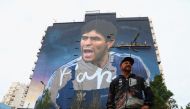 Artist Martin Ron poses for a picture in front of his mural depicting late soccer legend Diego Armando Maradona, which will be presented on the anniversary of Maradona, the 30th of October, in Buenos Aires, Argentina on October 19, 2022. REUTERS/Tomas Cuesta 