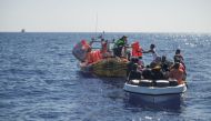 Crew members of NGO rescue ship 'Ocean Viking' give lifejackets to migrants on an overcrowded boat in the Mediterranean Sea, on October 25, 2022. Camille Martin Juan/Sos Mediterranee/Handout via REUTERS 