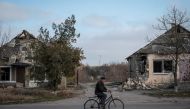 A local resident rides a bike near destroyed houses, amid Russia's attack on Ukraine, in the village of Arkhanhelske, Kherson region, Ukraine, November 8, 2022. (REUTERS/Viacheslav Ratynskyi)