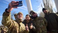 This handout photograph taken and released by Ukrainian Presidential press service on November 14, 2022, shows Ukrainian President Volodymyr Zelensky (2nd left) posing for a selfie with Ukrainian servicemen during his visit to the newly liberated city of Kherson, following the retreat of Russian forces from the strategic hub. (Ukrainian Presidential Press Service / AFP) 
