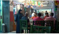 Shams al-Qassabi, the owner of the Shay al-Shamous restaurant, talks with a group of United States football supporters, in Doha, Qatar, November 23, 2022. (REUTERS/Will Russell)