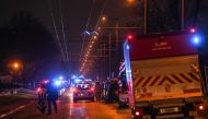 Policemen guard a security perimeter as firefighters and rescuers work in a building of the Mas-Du-Taureau quarter where a fire caused many victims, including children, on December 16, 2022 in Vaulx-en-Velin. Photo by OLIVIER CHASSIGNOLE / AFP