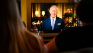 A family sits in a living room in Liverpool, as they watch Britain's King Charles III delivering his first annual Christmas Day message, on television, on December 25, 2022. (Photo by Paul ELLIS / AFP)