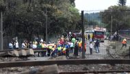 People gather near a burnt out truck at the entrance of the damaged bridge where a gas tanker exploded in Boksburg near Johannesburg, South Africa, on December 24, 2022. (REUTERS/Sumaya Hisham)