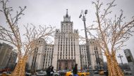 Pedestrians walk past Christmas and New Year decorations in front of the Red Gate Building Stalin-era skyscraper in Moscow, on December 28, 2022. (Photo by Yuri KADOBNOV / AFP)