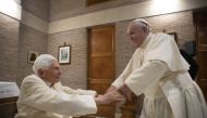 This photo taken and handout on November 28, 2020 by The Vatican Media shows Pope Francis (R) greeting Pope Emeritus Benedict XVI following a consistory to create 13 new cardinals, on November 28, 2020 in The Vatican. (Photo by Vatican Media / AFP)