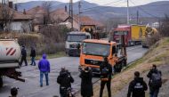 Journalists film as Kosovo Serbs remove trucks from a road barricade set up by ethnic Serbs in the village of Rudare near the town of Zvecan on December 29, 2022.  (Photo by Armend NIMANI / AFP)