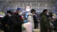 Passengers, some wearing personal protective gear to halt the spread of Covid-19, queue at a train station in Beijing on January 5, 2023. (Photo by Noel Celis / AFP)