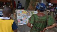 Local residents read the headlines of local newspapers after the release of 46 Ivorian soldiers arrested in July 2022 in Mali, in Abidjan on January 7, 2023.  (Photo by Issouf SANOGO / AFP)