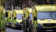 Military personnel and an ambulance worker walk between parked ambulances outside their Waterloo station, amid a strike by ambulance workers due to a dispute with the government over pay, in London, Britain on January 11, 2023. REUTERS/Toby Melville/File Photo
