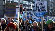 People hold placards as they take part in a protest march organised by Doctors Association UK, NHS Workers Say No! and NHS Staff Voices, from University College London to Downing Street, in London on January 18, 2023, in support of the ongoing pay disputes.  (Photo by CARLOS JASSO / AFP)