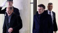 French President Emmanuel Macron and German Chancellor Olaf Scholz leave the Elysee Palace prior to their dinner, as part of the celebration of the 60th anniversary of the signing of the Elysee Treaty, to seal reconciliation between France and West Germany, 18 years after the Second World War at the presidential Elysee Palace in Paris on January 22, 2023. (Photo by Ludovic MARIN / AFP)