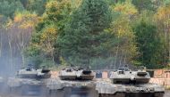 This file photo taken on October 13, 2017 shows an armored unit with Leopard 2 A7 main battle tanks of the German armed forces Bundeswehr driving through the mud in the context of an informative educational practice 