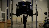 A worker stands beneath a TX electric taxi inside the LEVC (London Electric Vehicle Company) factory in Coventry. File Photo: Phil Noble/Reuters
