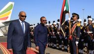 Ethiopian Prime Minister Abiy Ahmed (R) walks alongside Sudanese Army Chief Abdel Fattah al-Burhan (L) at Khartoum Airport during a welcome ceremony on January 26, 2023. (Photo by AFP)