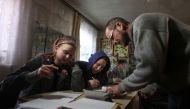 Ukrainian teacher Oleksandr Pogoryelov, 45, gives lessons to students in the living room of his house in Shandrigolovo, Donetsk region, on January 24, 2023. (Photo by Anatolii Stepanov / AFP)