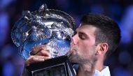 Serbia's Novak Djokovic poses with the Norman Brookes Challenge Cup after his victory against Greece's Stefanos Tsitsipas during the men's singles final of the Australian Open tennis tournament in Melbourne on January 29, 2023. (Photo by William West/AFP)