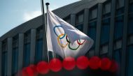 This file photo taken on March 8, 2021 shows the Olympic flag floating next to the headquarters of the International Olympic Committee in Lausanne. (Photo by Fabrice Coffrini / AFP)