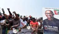 Supporters chant party slogans next to a banner of the candidate of the Labour Party Peter Obi during a campaign rally of the party in Lagos, on February 11, 2023. (Photo by PIUS UTOMI EKPEI / AFP)