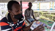 A man points at a newspaper in Lagos, on February 26, 2023, the day after Nigeria's presidential and general election. (Photo by John Wessels / AFP)