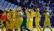 Australia's players celebrate as South Africa's Tazmin Brits (front) walks back to the pavilion after her dismissal during the final T20 women's World Cup cricket match between South Africa and Australia at Newlands Stadium in Cape Town on February 26, 2023. (Photo by Marco Longari / AFP)