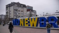 Kosovan Albanians walk past the newborn monument changed to 