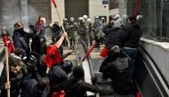 Protesters run from police into a metro station during a massive demonstration in Athens on March 5, 2023, following the deadly train accident late on February 28. (Photo by Louisa Gouliamaki / AFP)