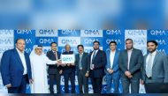 QIMA officials displaying the new logo.