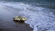 A wreath of flowers floats on the Mediterranean Sea, thrown by people who ended a protest march on the beach at the site of the shipwreck on March 11, 2023 in Steccato di Cutro, Calabria region, southern Italy, as part of the movement 'Stop the massacre, now!' (Fermare la strage, subito!) launched by the 'National Network February 26' created following the February 26, 2023 shipwreck that killed at least 74 migrants, including children, in Steccato di Cutro. (Photo by Gianluca CHININEA / AFP)