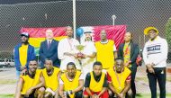 Ghana Ambassador to Qatar H E Mohamed Nurudeen Ismaila, Walking Football Federation President Farhan Al Sheikh Al Sayed and LuLu International Regional Operations Manager Simon Alexander with the Ugandan team, winners of the tournament.