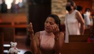 A woman prays before a Viacrucis at the Metropolitan Cathedral in Managua, on March 17, 2023. (Photo by OSWALDO RIVAS / AFP)