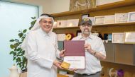 Director of QCDC Abdullah Al Mansoori awarding a certificate to a participant. 