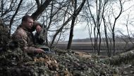 A Ukrainian serviceman sits on the T-72 tank on the front line near Bakhmut, on March 26, 2023, amid the Russian invasion of Ukraine. (Photo by Sergey SHESTAK / AFP