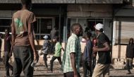 Protesters walk in front of a looted shop in Nairobi, on March 30, 2023 during a protest called by the opposiion coalition 