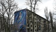 A mural depicting a woman with a child is seen on a wall of a heavily damaged residential building in the frontline town of Avdiivka, Donetsk region on April 4, 2023. (Photo by Genya Savilov / AFP)
 