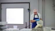 A cheesemaker pours curds into moulds to make Tunworth cheese in the production room at the Hampshire Cheese Company near Basingstoke in Hampshire south east England, on March 14, 2023. Photo by Adrian DENNIS / AFP