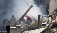 Firefighter work on rubble at the 'rue Tivoli' after a building collapsed in the same street, in Marseille, southern France, on April 9, 2023. (Photo by CLEMENT MAHOUDEAU / AFP)