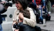 A parent escorts her child following a shooting at a school in the capital Belgrade on May 3, 2023.  (Photo by Oliver Bunic / AFP)