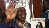 Enose Mukami Kimathi holds the portrait of her husband Dedan Kimathi, former Mau Mau freedom fighter who was hanged half a century ago by the colonial government. (Photo by SIMON MAINA / AFP)