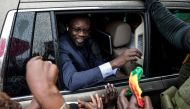 (FILES) Ousmane Sonko (C), President of the opposition party Senegalese Patriots for Work, Ethics and Brotherhood (PASTEF), waves good bye to his supporters at the HLM basic school in Ziguinchor on July 3, 2022. (Photo by MUHAMADOU BITTAYE / AFP)