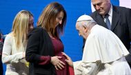 Pope Francis blesses a pregnant woman at the end of a conference in Rome on May 12, 2023 during a two-day 'General States of Birth' conference. (Photo by Filippo Monteforte / AFP)