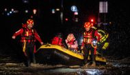 Firemen and civil protection rescuers evacuate a woman with an inflatable boat in Forli on May 17, 2023 after heavy rains have caused major floodings in central Italy, where trains were stopped and schools were closed in many towns while people were asked to leave the ground floors of their homes and to avoid going out. Photo by AFP