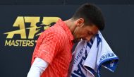 Serbia's Novak Djokovic wipes his face during his quarterfinals match of the Men's ATP Rome Open tennis tournament against Denmark's Holger Rune, at Foro Italico in Rome on May 17, 2023. (Photo by Filippo MONTEFORTE / AFP)