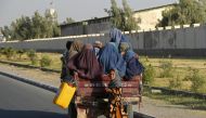 File Photo: Some Afghan women travel in a vehicle along the road in Kandahar on December 25, 2022. (Photo by Naveed Tanveer / AFP)